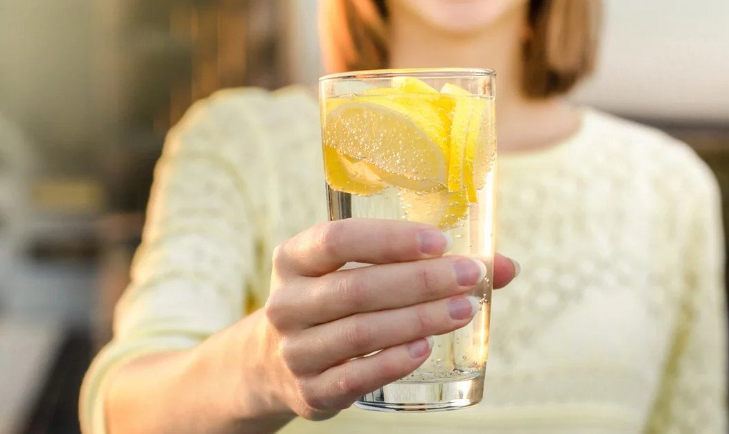 Пить стакан воды натощак. Стакан воды с лимоном. Лимонад в руке. Пить воду с лимоном.